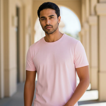 Male model wearing a light pink t-shirt standing in front of architectural columns. Plain Light Pink Men's T-shirt by Paryatak Travel Shop.