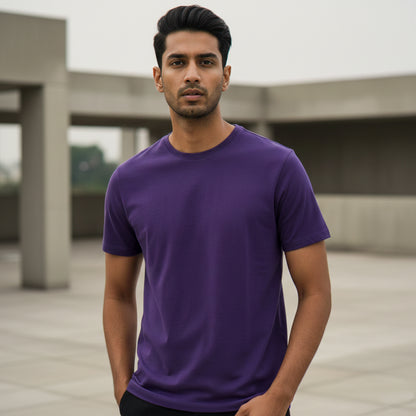 Male model wearing a purple t-shirt standing outdoors with a blurred background. Plain Purple Men's T-shirt by Paryatak Travel Shop
