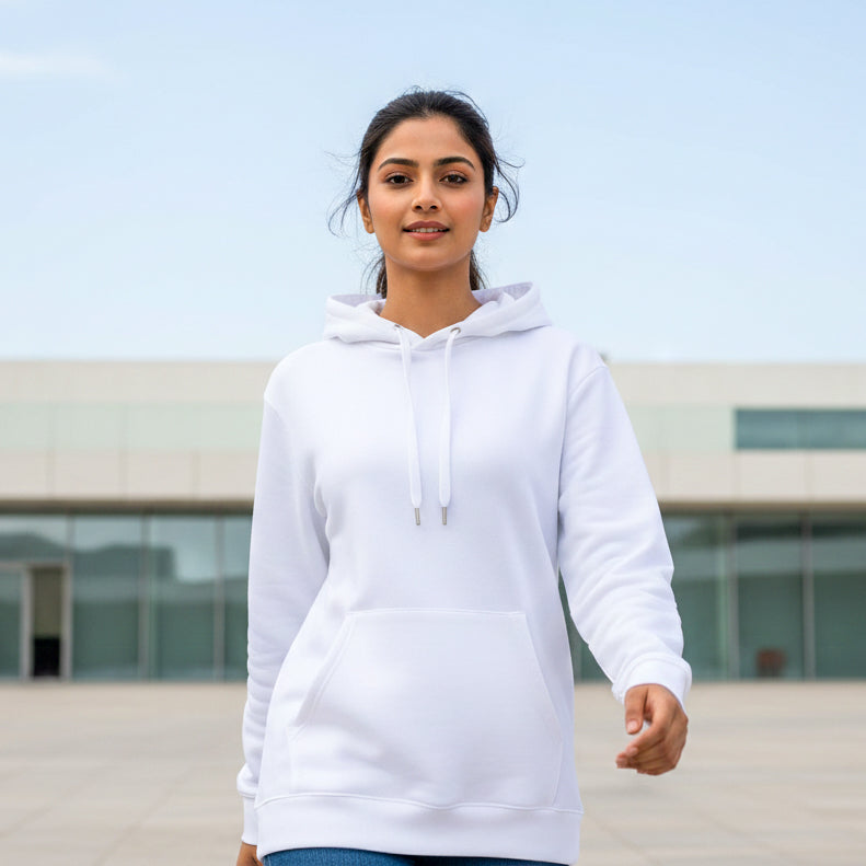 Female model wearing a white hoodie standing outdoors with a building in the background. Plain White Hoodie by Paryatak Travel Shop.